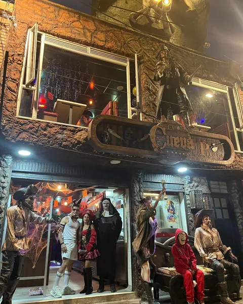 Fachada de La Cueva del Pirata en Kennedy, Bogotá, con su aviso de madera tallada y clientes en la entrada