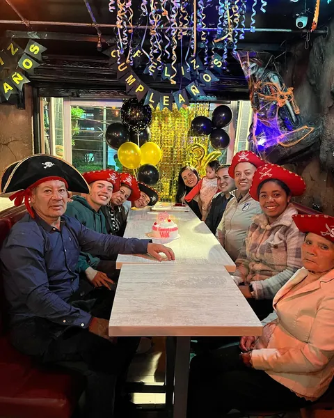Familia celebrando un cumpleaños con sombreros piratas en una mesa larga de La Cueva del Pirata