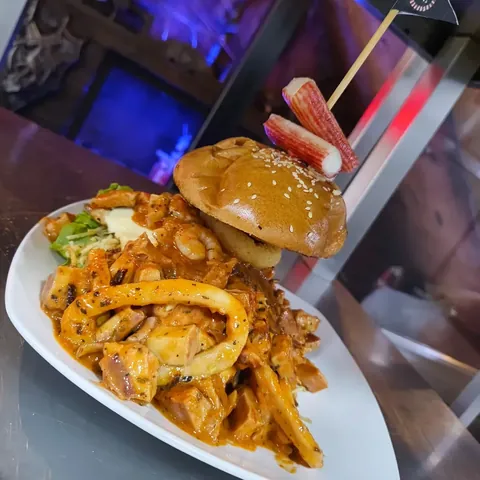Hamburguesa artesanal acompañada de aros de calamar y palmitos de cangrejo en salsa