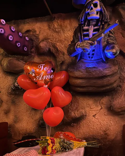 Rincón de la cueva con la figura de un pirata esqueleto y decoración de globos rojos en forma de corazón