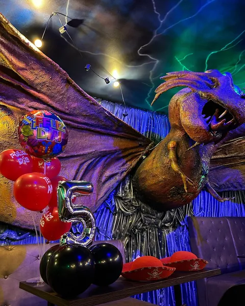 Salón del restaurante con la figura del Kraken colgando del techo y globos de celebración